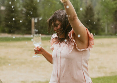 Woman dancing at a reception with champagne bubbles spray in the foreground