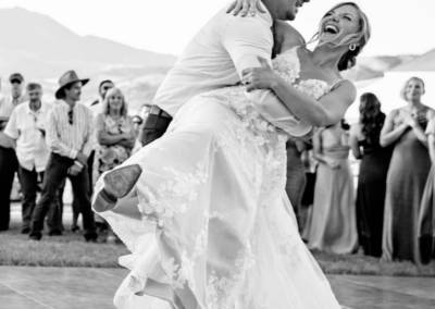 Groom dipping bride on an outdoor dance floor rented from Gallatin Event Rentals