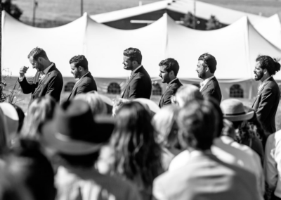 Groomsmen at wedding ceremony with an outline of the wedding reception peaks highlighted behind them