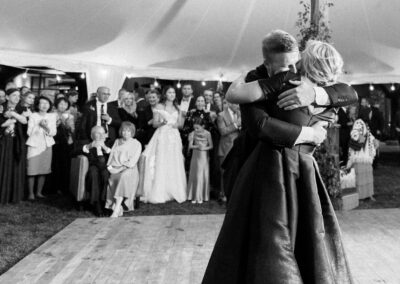 Son and mother sharing a wedding dance under a tent canopy