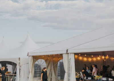 Woman walking past outdoor structure decorated for a dinner event