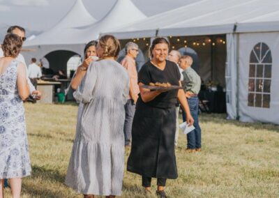 Guests enjoying appetizers outside a high peak tent setup